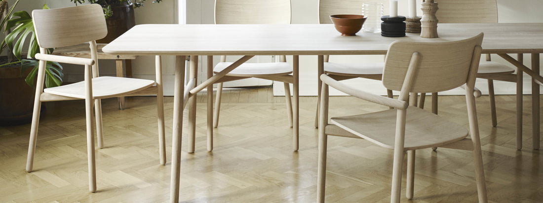 La table à manger Hven 94 × 260 cm avec le fauteuil Hven de Skagerak dans la vue d'ambiance. La collection provient du designer suédois Anton Björsing.