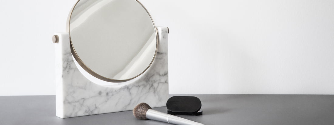 Image d'ambiance du miroir en marbre Pepe de Menu. Le miroir se présente sous une forme intemporelle et convient parfaitement comme miroir de maquillage dans la salle de bains.