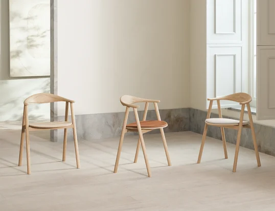 La chaise à accoudoirs Swing se distingue par son aspect léger et d'inspiration scandinave, et son dossier incurvé assure un excellent confort d'assise.