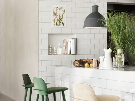 Der Nerd Barhocker aus Holz und die Unfold Pendelleuchte in grau sind moderne Accessoires für die Küche - entworfen vom skandinavischen Hersteller Muuto.