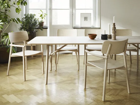 La table à manger Hven 94 × 260 cm avec le fauteuil Hven de Skagerak dans la vue d'ambiance. La collection est l'œuvre du designer suédois Anton Björsing.