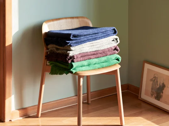 Vue d'ambiance de la couverture en laine Mono de Hay : la couverture douce avec ses franges ludiques est un véritable accroche-regard et assure une chaleur suffisante pour les jours froids.