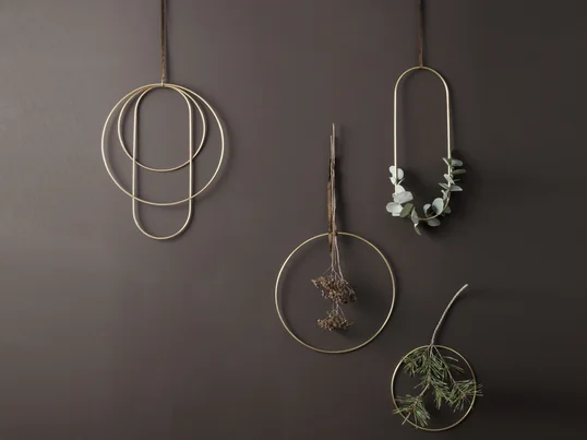 Les anneaux en laiton doré de ferm Living dans la vue d'ambiance : les cadres créent une ambiance festive au mur ou au-dessus du rebord de fenêtre et peuvent être entourés de branches ou de brindilles.