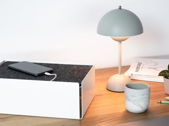 La boîte de chargement de Konstantin Slawinski dans la vue d'ambiance : La boîte cache les câbles de chargement des iPhones, des appareils photo et d'autres dispositifs avec style sur la table de cuisine.