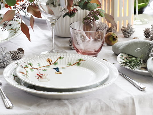 Les assiettes de Noël Hammershøi de Kähler Design dans la vue d'ambiance. La vaisselle noble blanche peut aussi être joliment combinée avec de la vaisselle en verre.