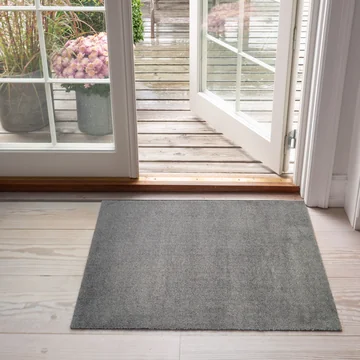 Le paillasson Unicolor de tica copenhagen devant la porte de la terrasse