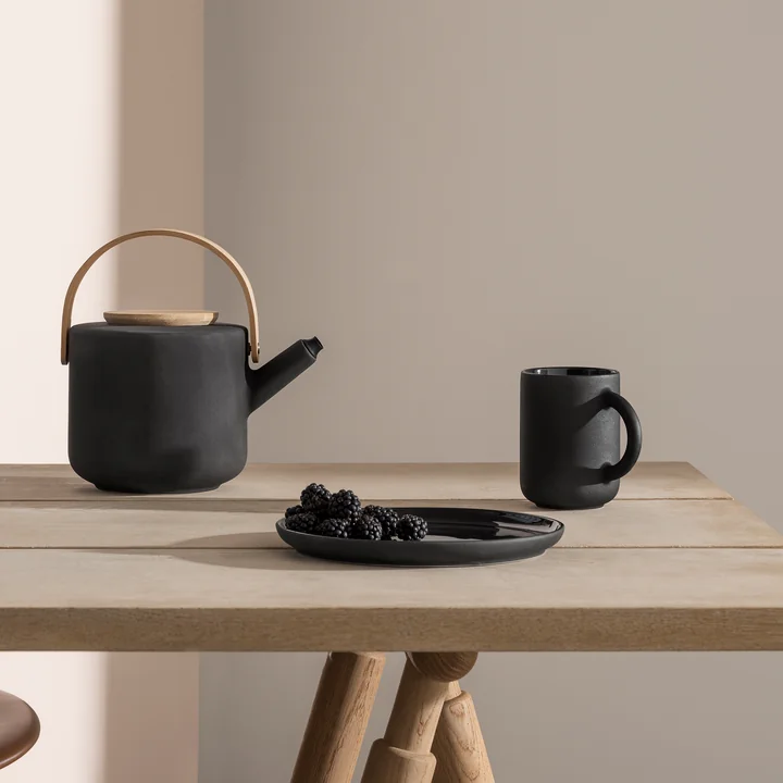 Les mugs et la théière Theo de Stelton sur la table
