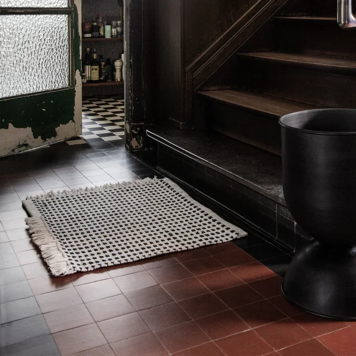 Way Outdoor Mat, 50 x 70 cm en blanc cassé / bleu de Ferm Living in front of the stairs