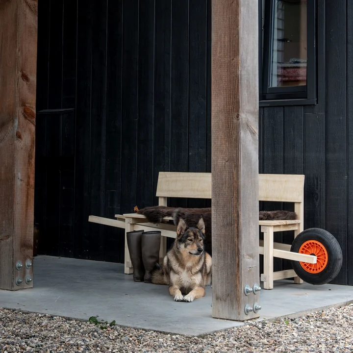 Wheelbench de Weltevree avec une peau de mouton devant la maison