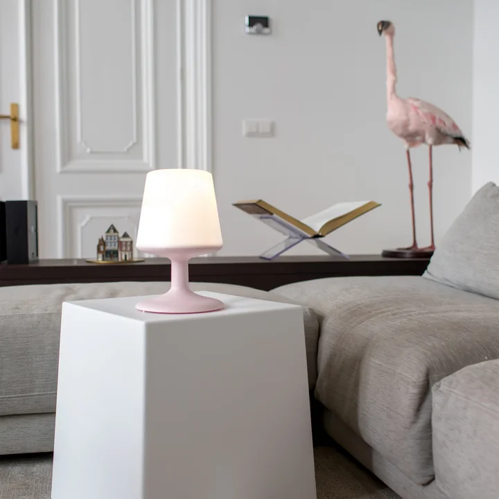 Lampe de table à piles en rose bio de Koziol sur la table basse.