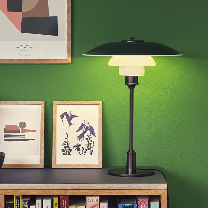 La lampe de table PH, noire de Louis Poulsen sur une étagère de bibliothèque