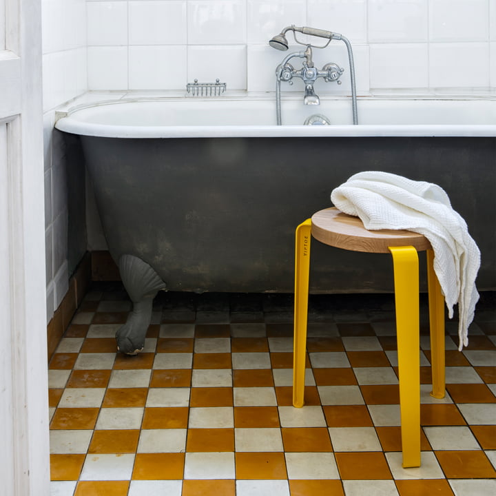 Le tabouret LOU Chêne naturel, jaune tournesol comme tablette dans la salle de bain