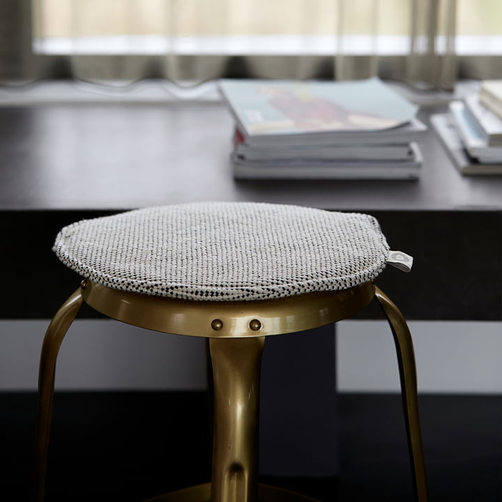 Le coussin d'assise pour chaise en rotin Cuun Ø 35 cm, noir / blanc de House Doctor sur un tabouret en métal