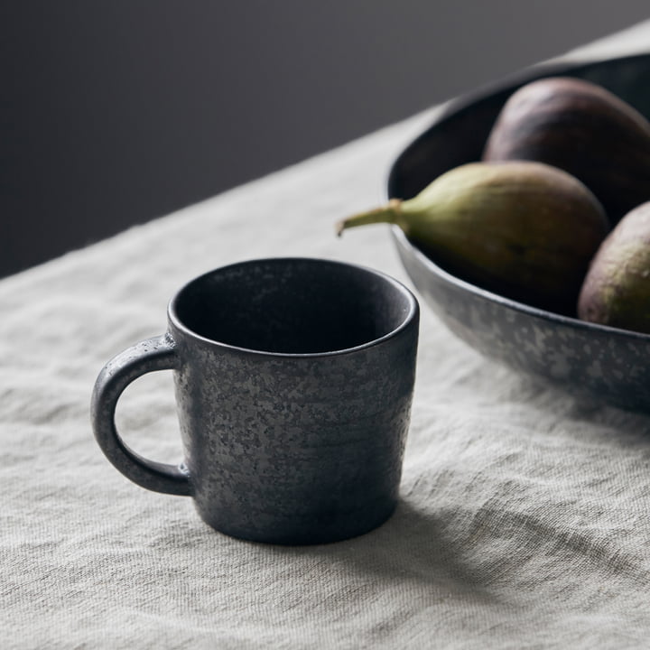 Le mug avec anse Pion devant une assiette de fruits