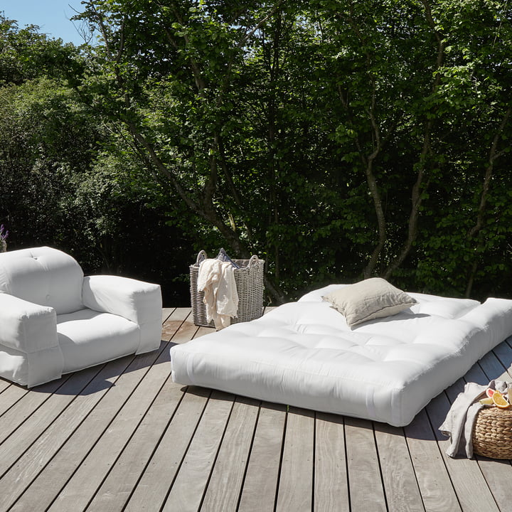 Les produits Hippo OUT de Karup Design sur une terrasse en bois entourée d'arbres et de buissons