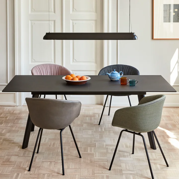 La lampe à suspension PC Linear rod, noir doux de HAY au-dessus d'une table à manger rectangulaire noire