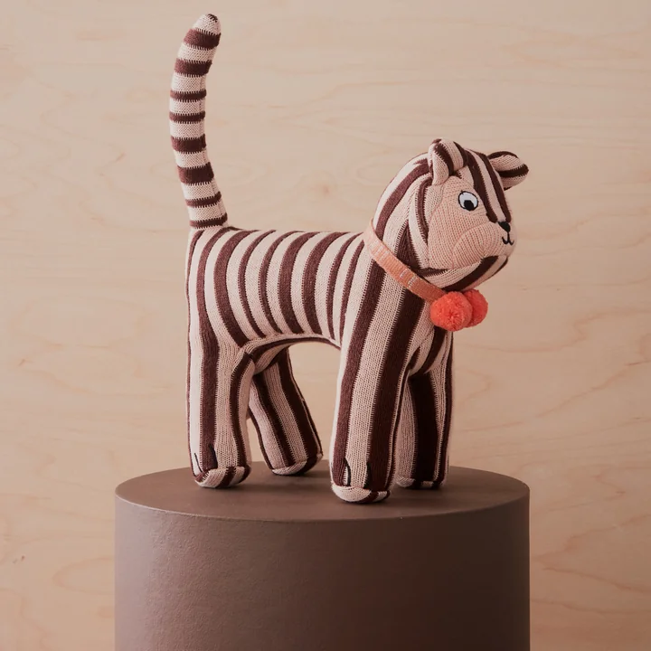 Le doudou en tricot de OYOY en tant que chat rayé avec collier