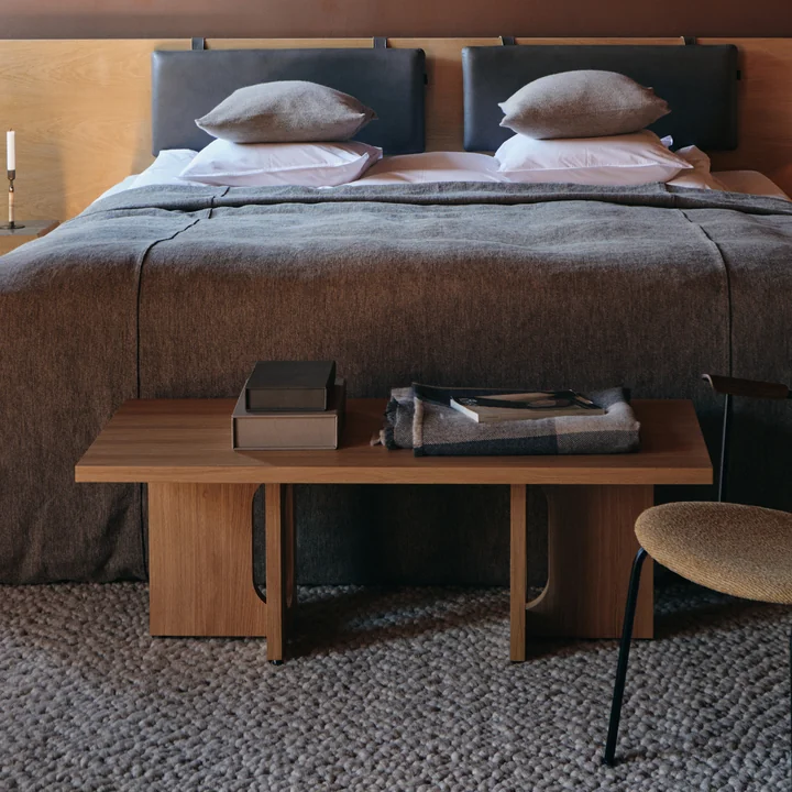 La table basse Androgyne 120 x 45 cm, chêne naturel de Audo comme tablette au bout du lit dans la chambre à coucher
