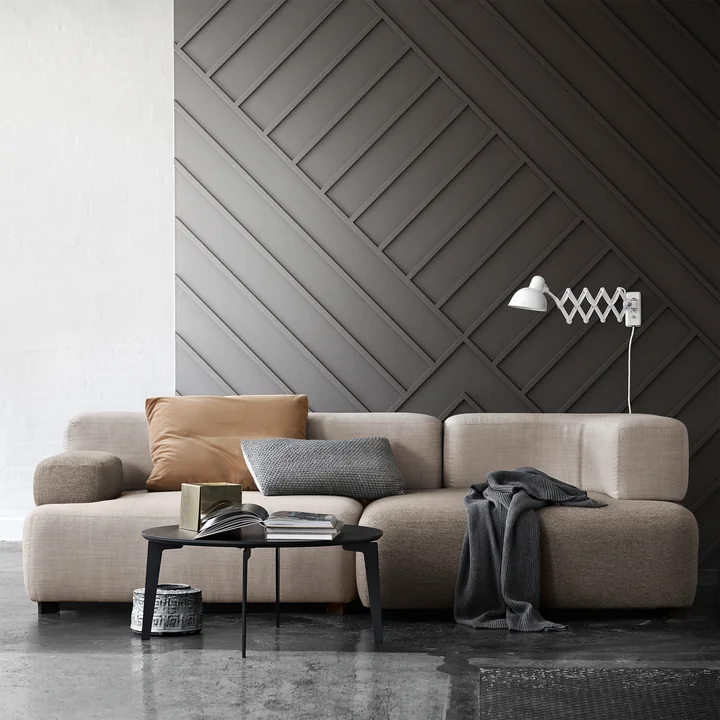 Le canapé modulaire Alphabet de Fritz Hansen avec des couvertures et des coussins de couleurs naturelles et une table basse noire