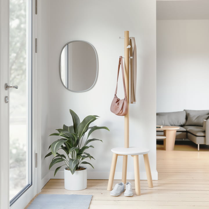 Le tabouret / portemanteau Pillar de Umbra dans le couloir lumineux à côté d'un miroir mural et d'une grande plante en pot