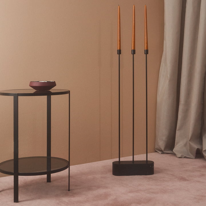Le chandelier Grasil pour le sol à côté AYTM d'une table d'appoint noire dans une pièce aux nombreux tons de rose