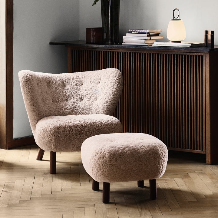 Le Lounge Chair Little Petra avec Pouf de & Tradition devant un habillage de radiateur sombre