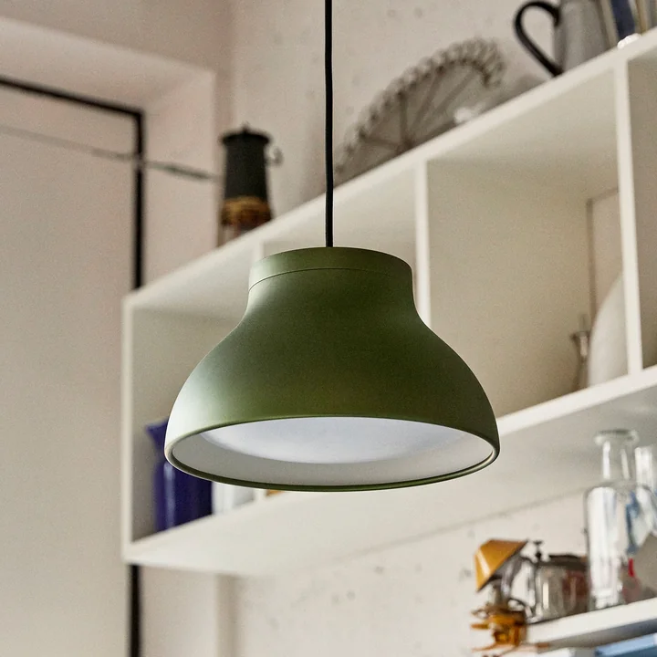 La lampe suspendue du HAY PC emerald green devant une étagère murale dans la cuisine