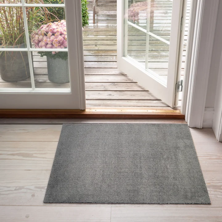 Le paillasson Unicolor de tica copenhagen devant la porte de la terrasse