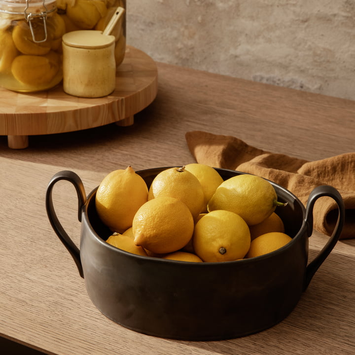 La coupe à fruits Flow de ferm Living en noir remplie de citrons