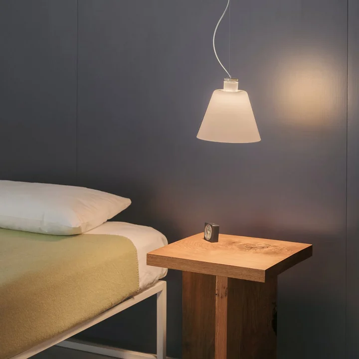 Le w202 Halo Lumière pendante LED S2 de Wästberg au-dessus de la table de nuit en bois à côté du lit