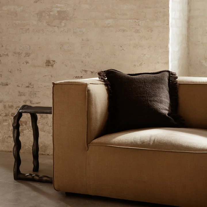 Le Kelim Cushion de Ferm Living in dark melange sur un volumineux canapé brun clair