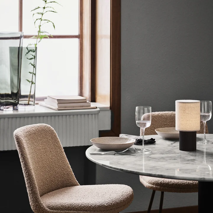 La lampe de table rechargeable Manhattan de & Tradition sur une table à manger ronde en marbre