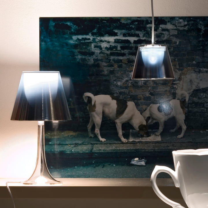 Le lumineux K Tribe S Lampe à suspension de Flos avec abat-jour de fumée devant une œuvre d'art