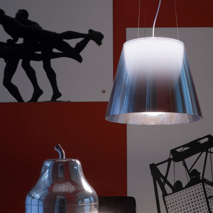 Le K Tribe S Lampe à suspension de Flos devant un mur rouge avec des photos en noir et blanc