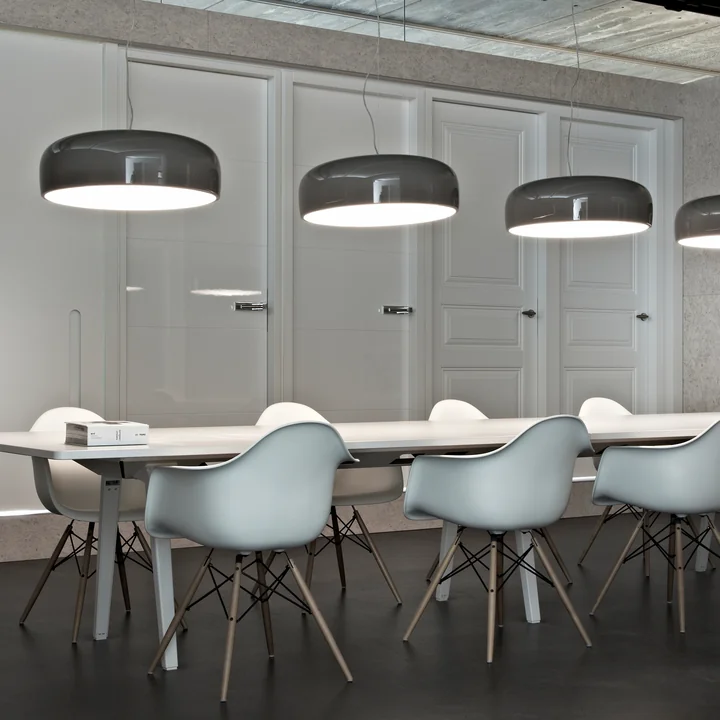 Smithfield Pro Les lumières suspendues de Flos au-dessus d'une longue table de conférence blanche