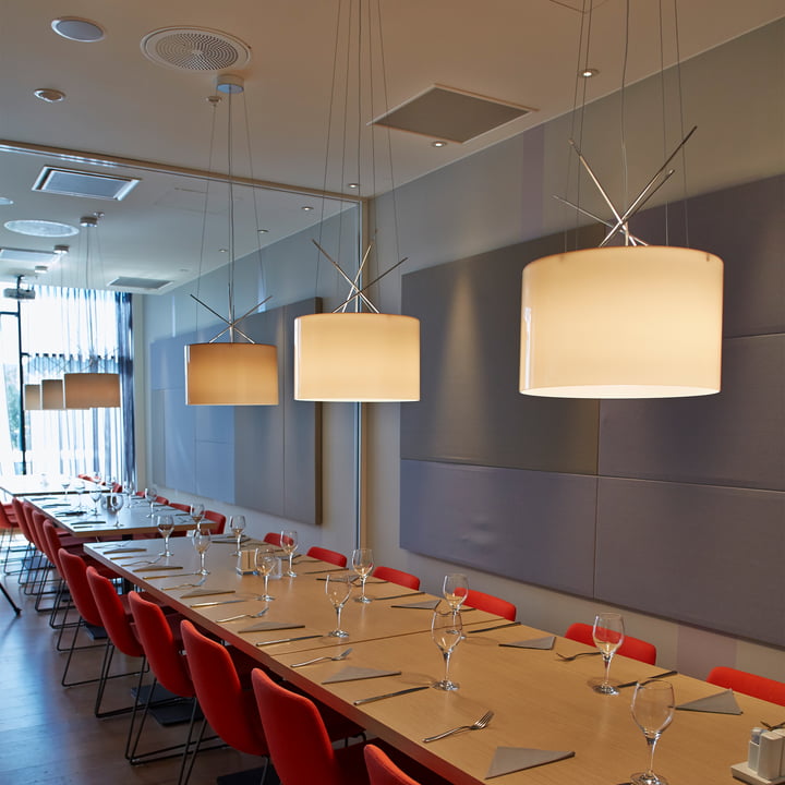 Les pendentifs Ray de Flos au-dessus d'une longue table dans un restaurant