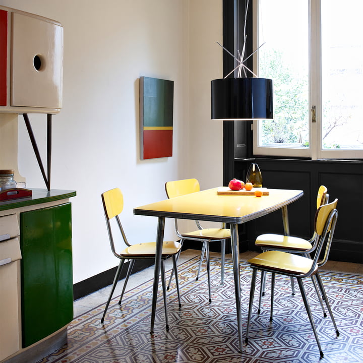 Le luminaire suspendu Ray de Flos au-dessus d'une petite table à manger dans une cuisine colorée