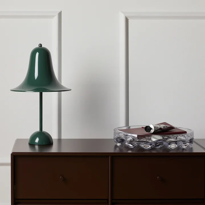 La lampe de table vert foncé Pantop de Verpan sur une commode en bois foncé