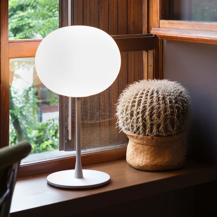La Glo-Ball T de Flos en argent mat sur un rebord de fenêtre à côté d'un cactus