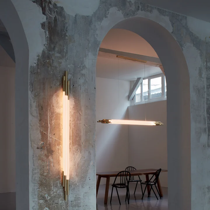 La lampe murale Org LED et la lampe à suspension de DCW dans une pièce rude avec de hauts plafonds.