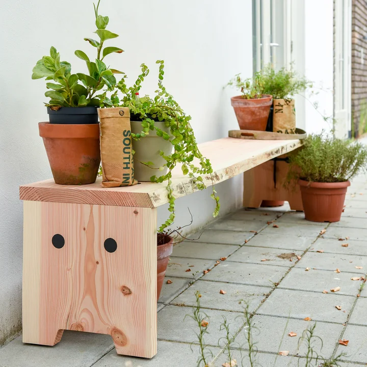 Le banc Forestry de Weltevree à l'extérieur avec de nombreuses plantes