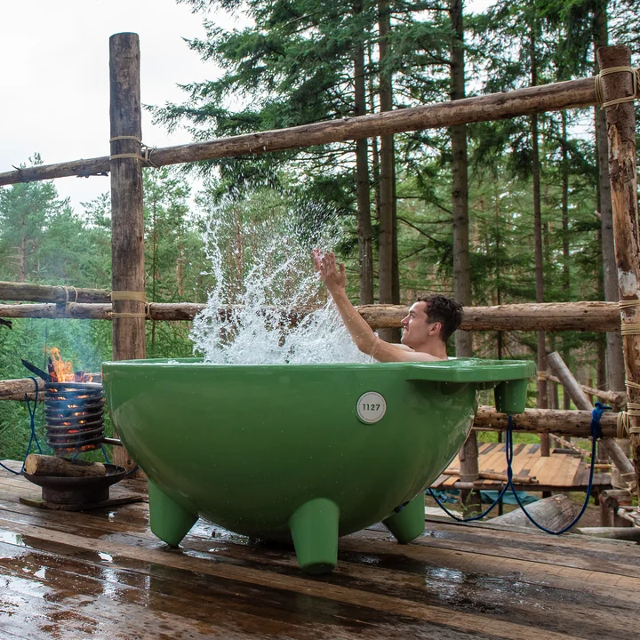 Le Dutchtub Original de Weltevree sur une haute plateforme en bois au milieu de la forêt