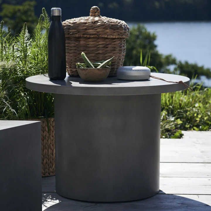 Stone La table latérale en béton de House Doctor sur la terrasse devant le lac