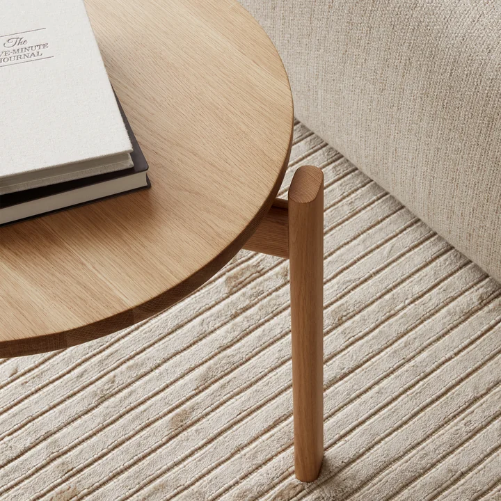 La table Passage Lounge de Audo sert de support pour les livres et les boissons.