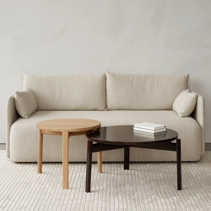 Les tables Passage Lounge de Audo en différentes laques devant le canapé