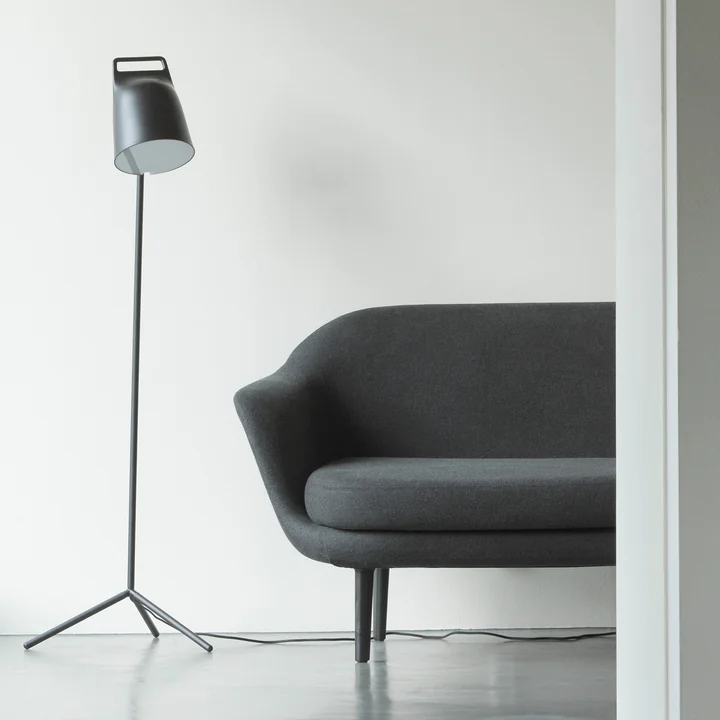 Le Stage Lampadaire LED de Normann Copenhagen à côté d'un canapé gris
