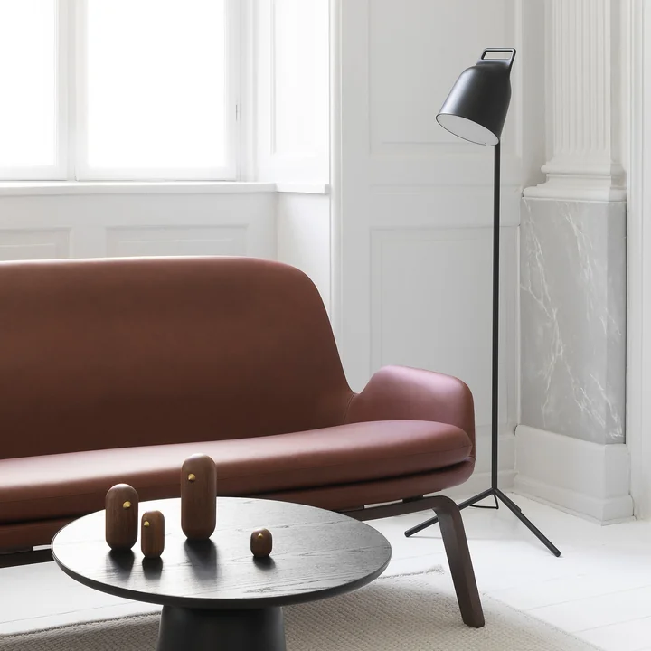 Le Stage Lampadaire LED de Normann Copenhagen à côté d'un canapé en cuir brun