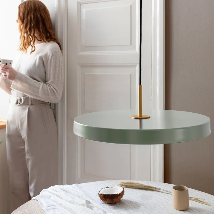 La lampe suspendue Asteria de Umage au-dessus de la table à manger