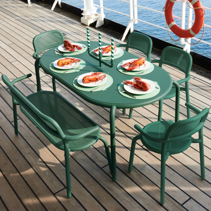 La table de jardin Toní avec chaises à accoudoirs et banc de Fatboy sur le pont d'un bateau