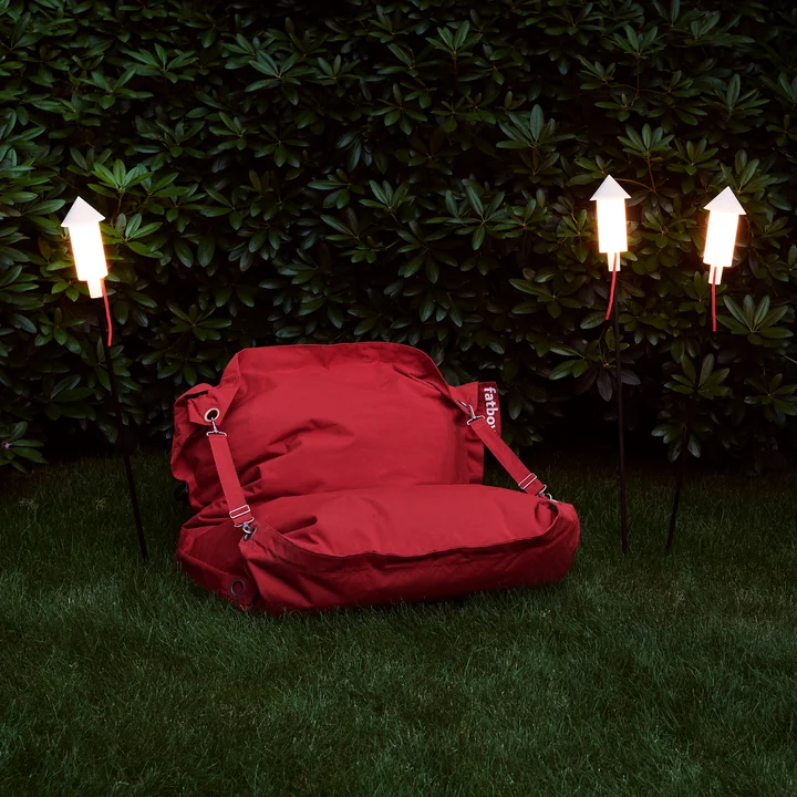 La lumière solaire Prêt a Racket dans le jardin à côté d'un canapé de Fatboy